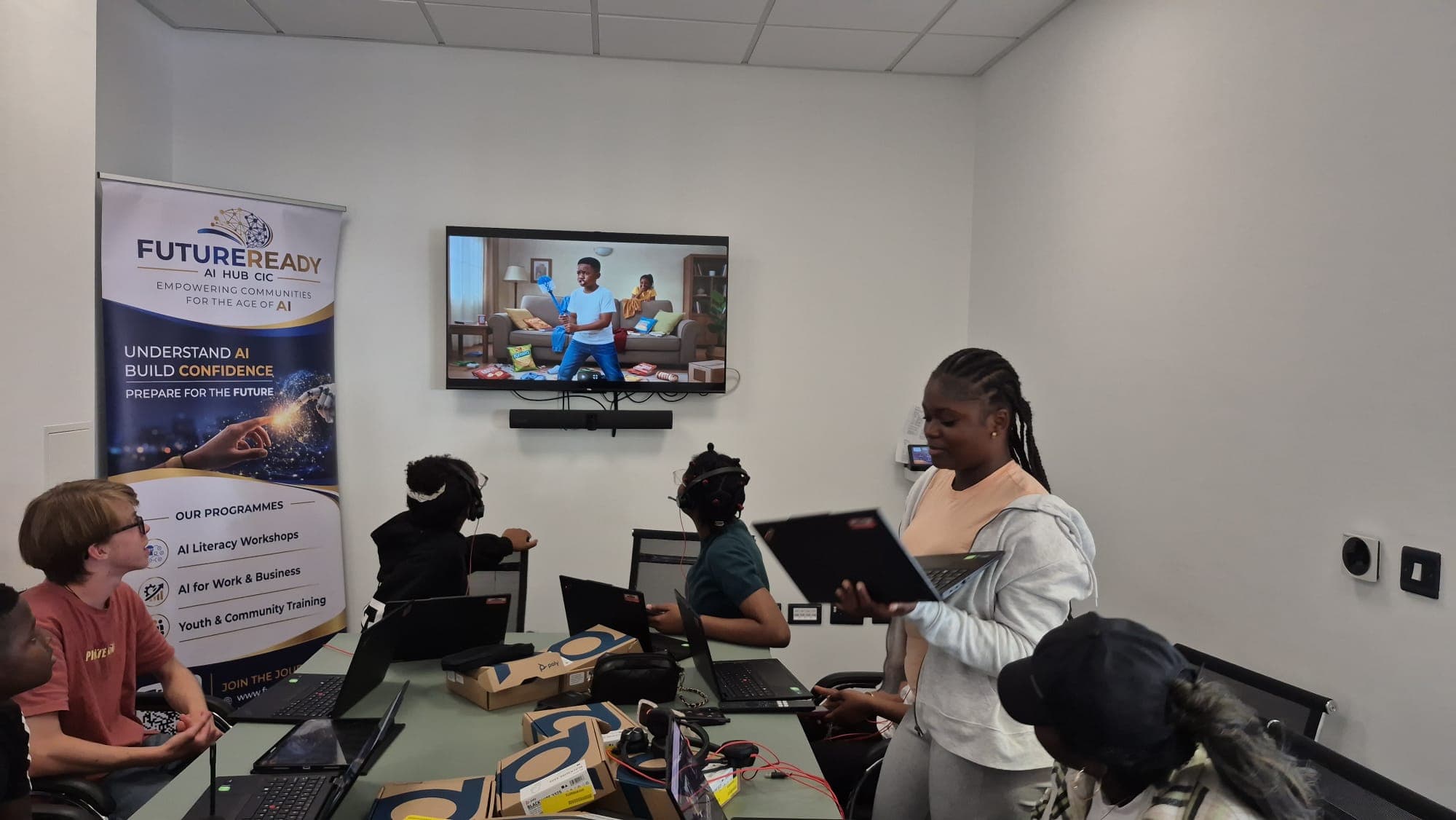 A participant presenting her work to the group while an AI-generated video plays on the screen behind her