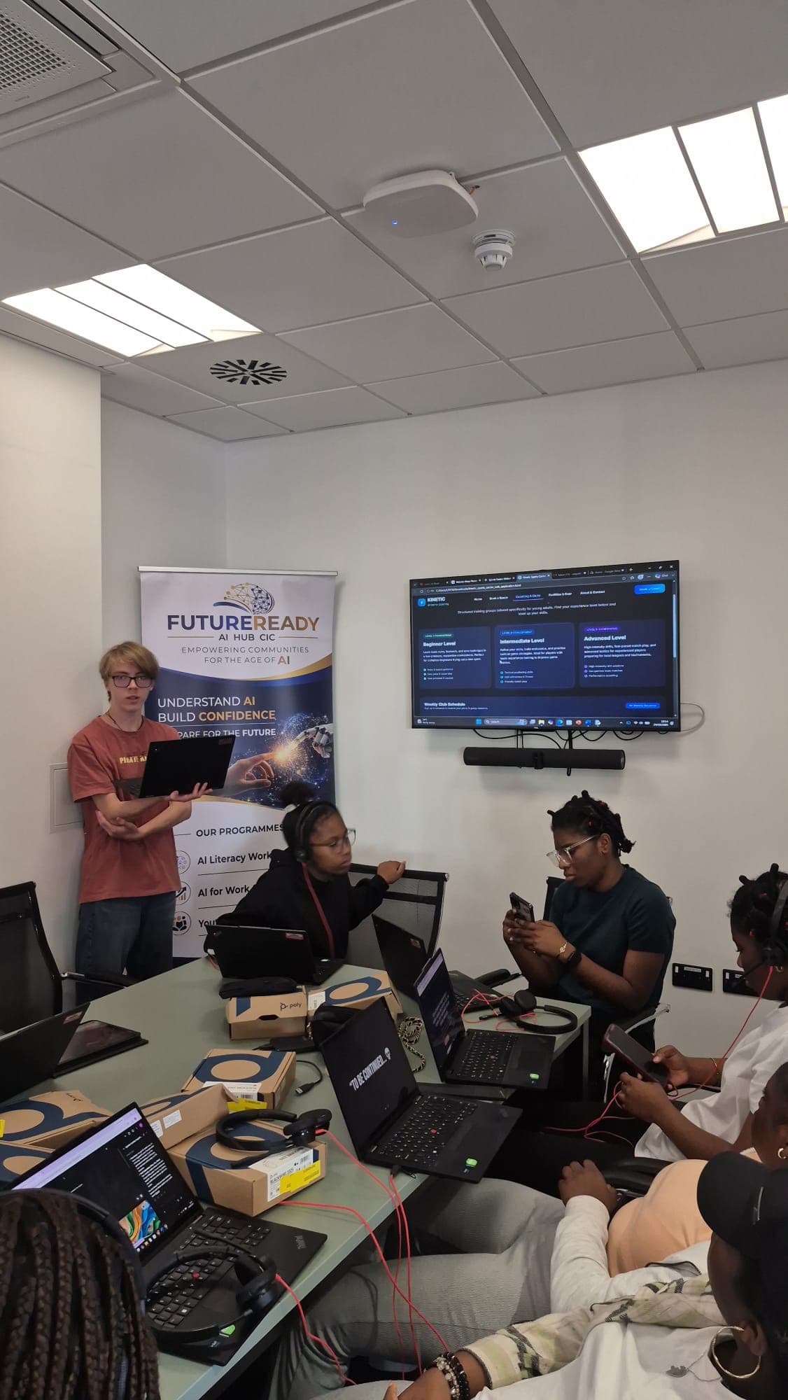 A participant presenting the sports club website he built to the rest of the group
