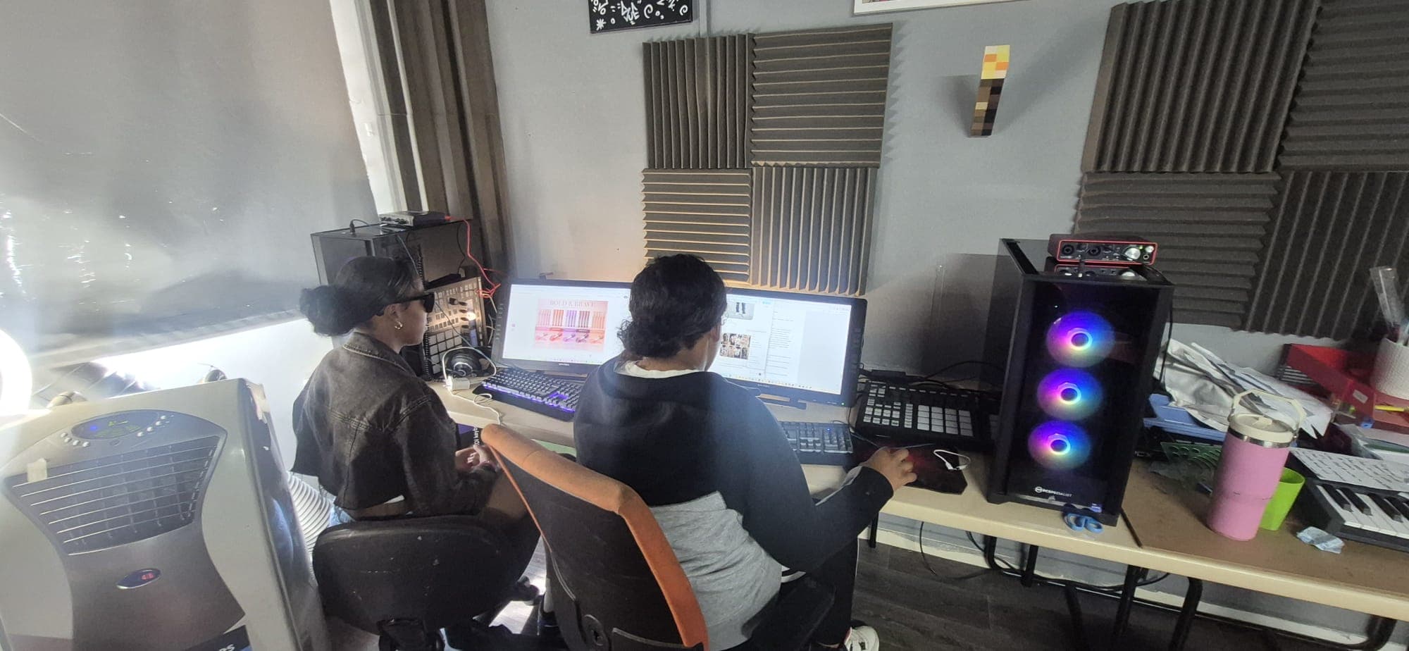Two participants working on a graphic design project on a studio workstation