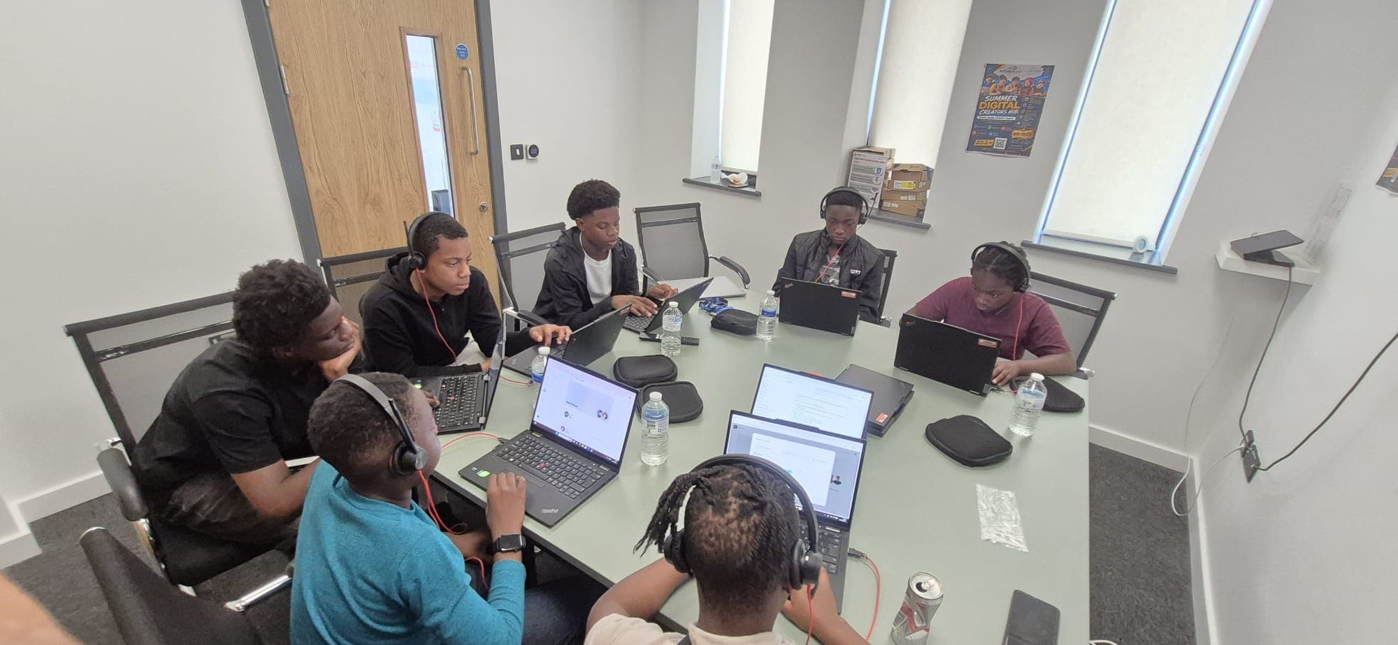 Participants working on their projects together around a table at the digital hub