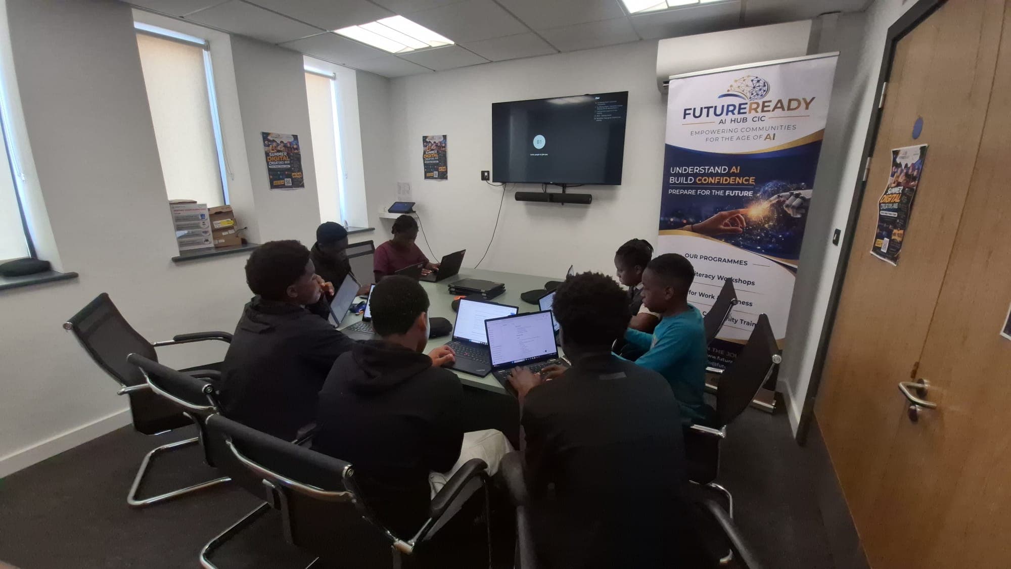 A group session at the digital hub with participants working on laptops